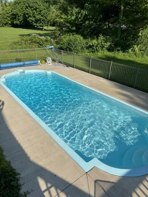 view of swimming pool with a fenced in pool and fence