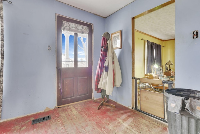 foyer entrance featuring wood finished floors and visible vents