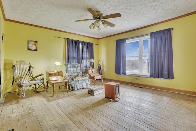 sitting room with visible vents, a textured ceiling, crown molding, and hardwood / wood-style flooring