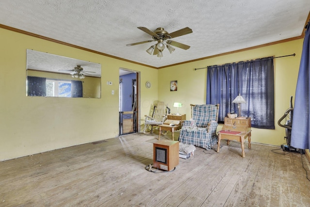 sitting room featuring ornamental molding, a textured ceiling, ceiling fan, and hardwood / wood-style floors