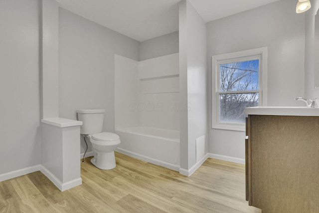 full bath featuring toilet, wood finished floors, baseboards, bathing tub / shower combination, and vanity