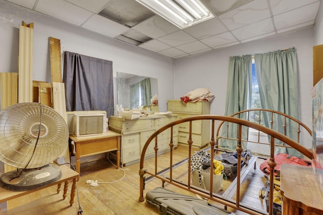 bedroom with a paneled ceiling and wood finished floors