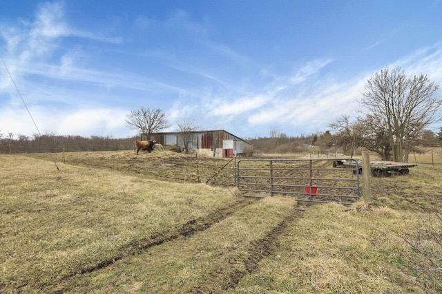 view of yard featuring an outbuilding, a rural view, a pole building, and fence