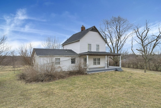 rear view of house with a lawn and a chimney