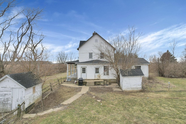 rear view of property with an outbuilding and a lawn