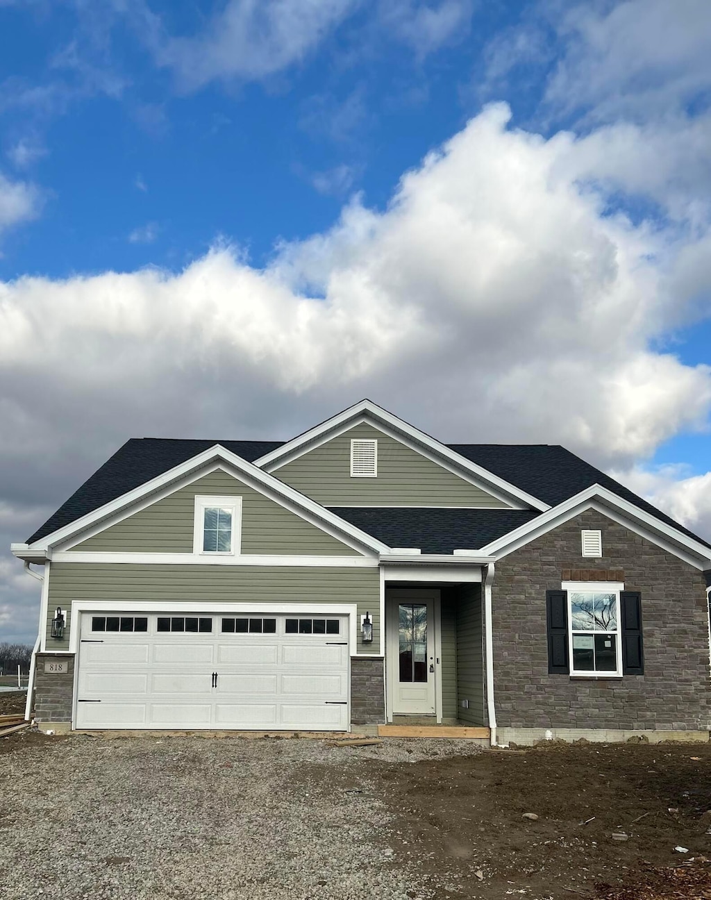 view of front of home featuring gravel driveway and an attached garage