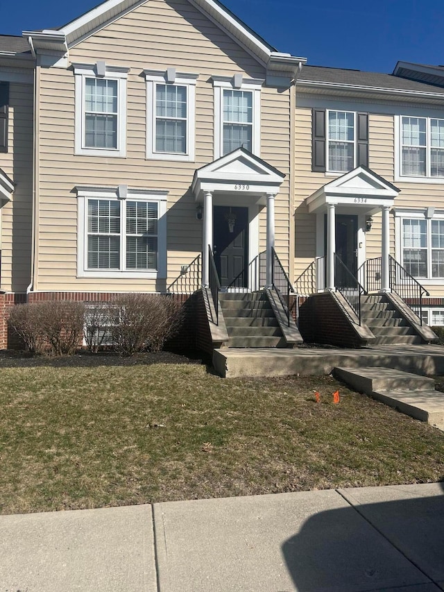 townhome / multi-family property with a front yard