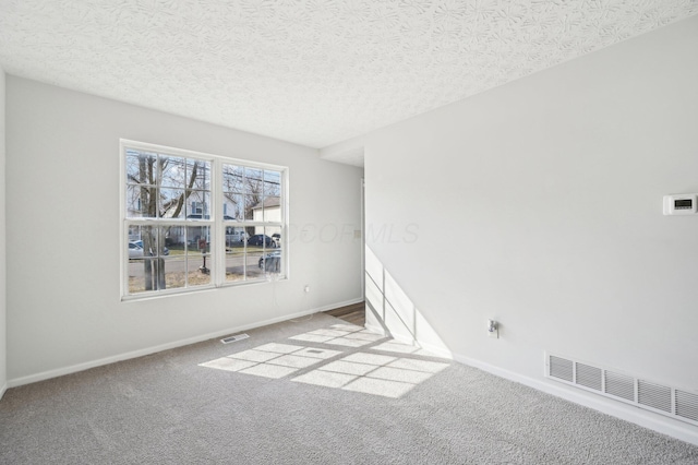 unfurnished room featuring visible vents, carpet floors, and baseboards