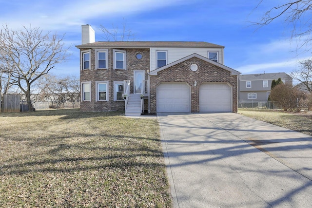 bi-level home with brick siding, a front lawn, fence, a chimney, and driveway