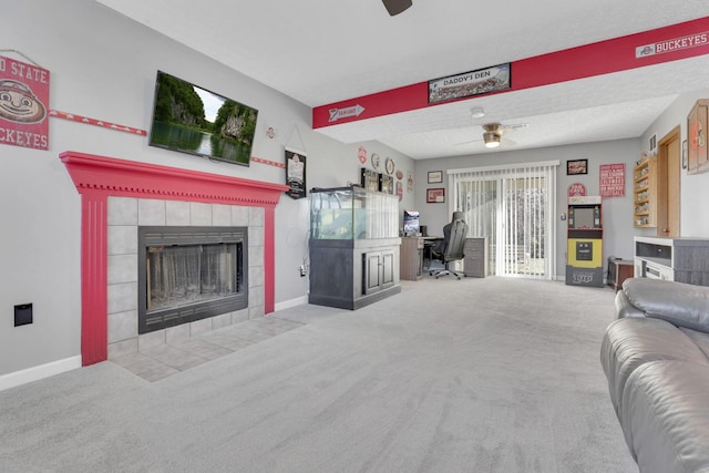 carpeted living room featuring a fireplace, baseboards, and ceiling fan