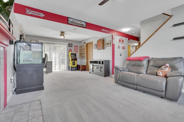 living area featuring a textured ceiling, carpet, and ceiling fan