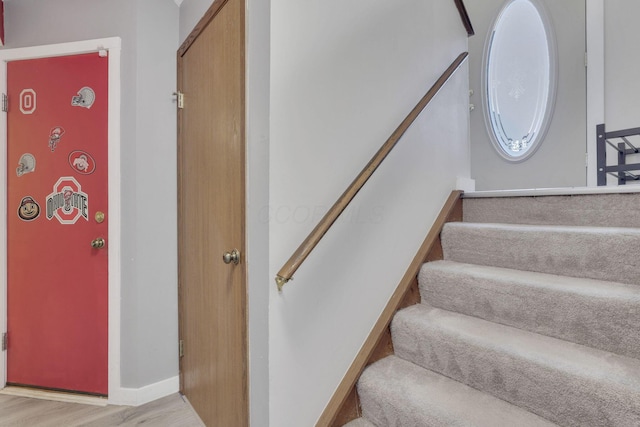 stairway featuring baseboards and wood finished floors