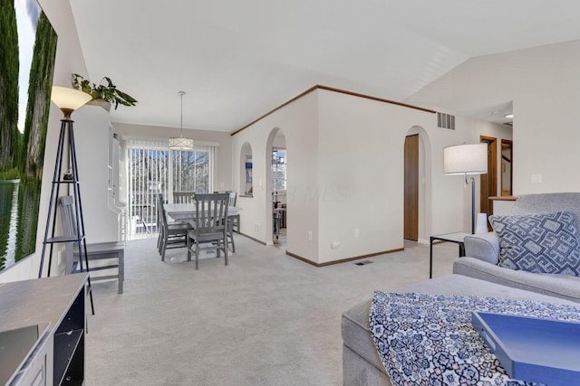 living area featuring arched walkways, visible vents, light colored carpet, and lofted ceiling