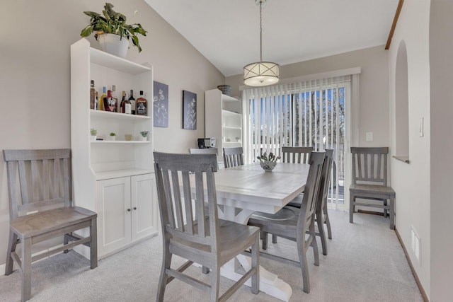 dining space featuring visible vents, light carpet, arched walkways, and baseboards