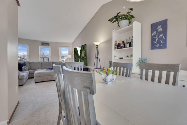 dining area featuring high vaulted ceiling and carpet floors