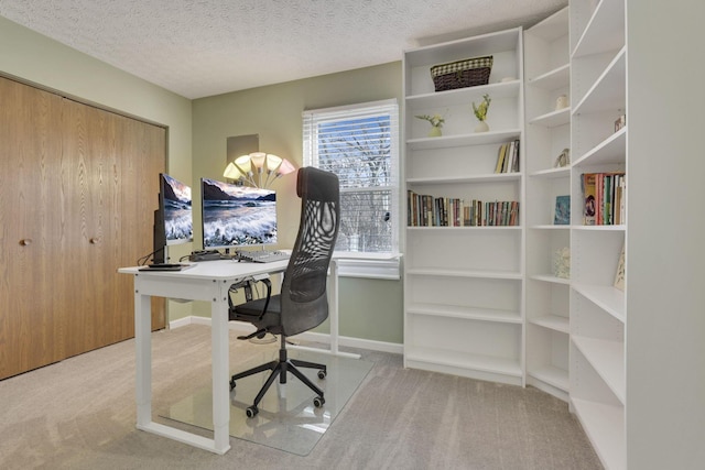 carpeted office featuring baseboards and a textured ceiling