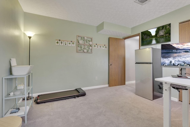 exercise room with baseboards, carpet flooring, a textured ceiling, and visible vents