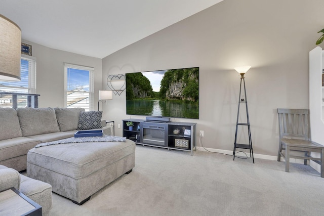 living area featuring lofted ceiling, carpet flooring, and baseboards