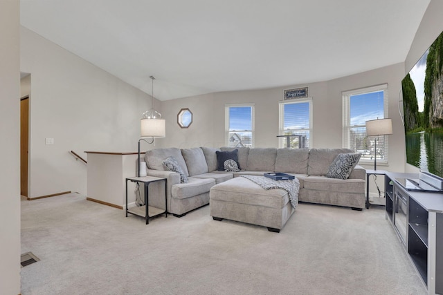 living area with visible vents, lofted ceiling, light colored carpet, and baseboards