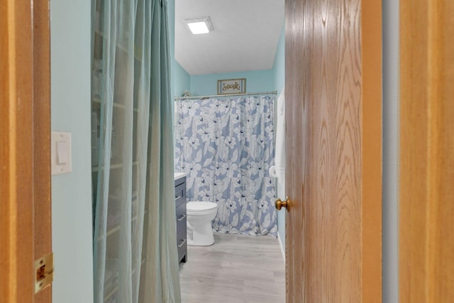 bathroom with vanity, toilet, a shower with curtain, and wood finished floors