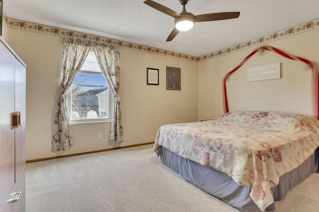 bedroom with ceiling fan, a textured ceiling, baseboards, and carpet