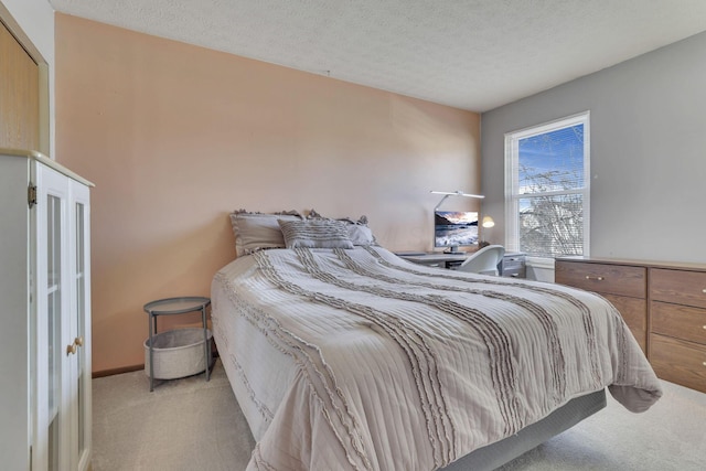 bedroom featuring light colored carpet, a textured ceiling, and baseboards