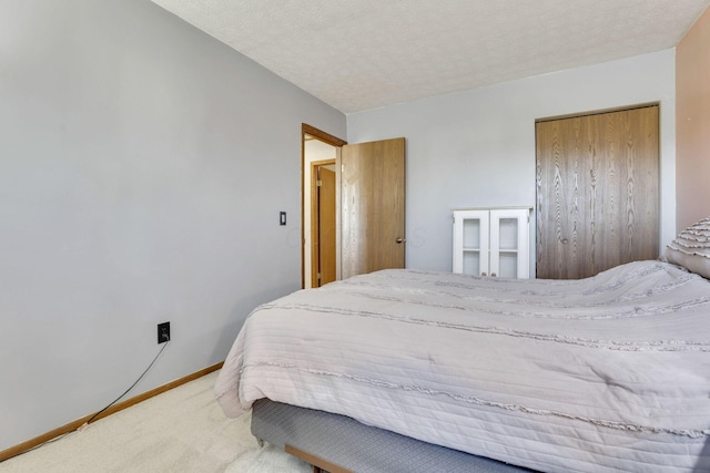 bedroom featuring baseboards, a textured ceiling, and carpet flooring