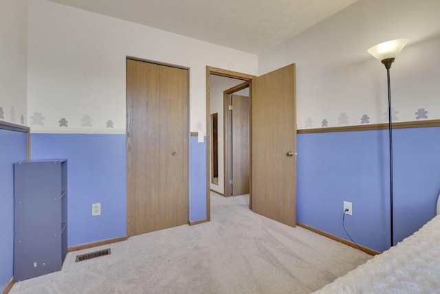 bedroom with a closet, visible vents, and carpet floors