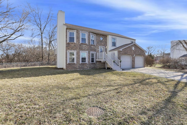 split foyer home with driveway, fence, a front yard, brick siding, and a chimney