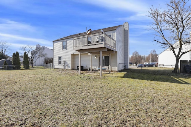 rear view of house with a wooden deck, a lawn, a fenced backyard, and a chimney