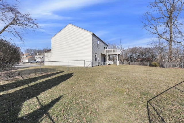 view of home's exterior featuring a deck, fence, and a lawn