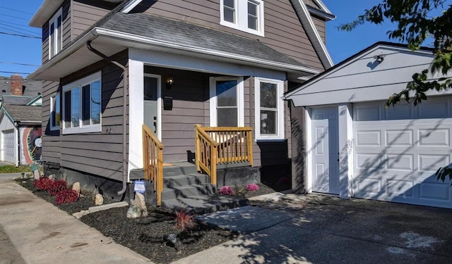 view of front of house with an outdoor structure, a garage, and roof with shingles