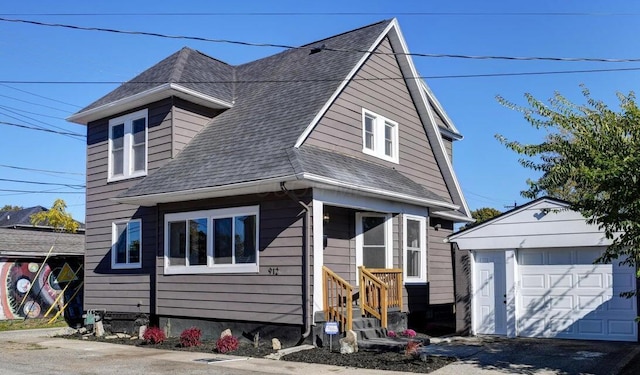 view of front of home with a garage, an outdoor structure, and roof with shingles