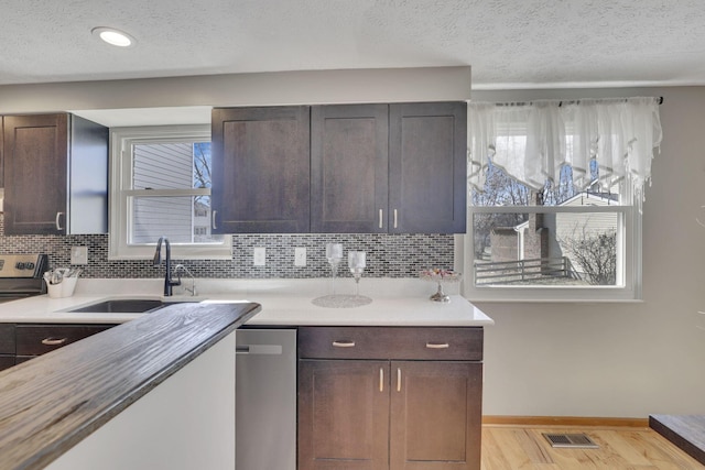 kitchen with visible vents, light wood-style flooring, stainless steel appliances, a sink, and light countertops