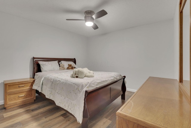 bedroom with a ceiling fan and dark wood-style flooring