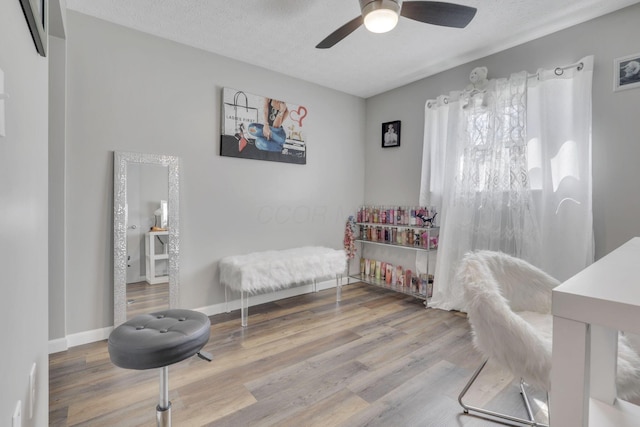 bedroom featuring baseboards, a textured ceiling, wood finished floors, and a ceiling fan