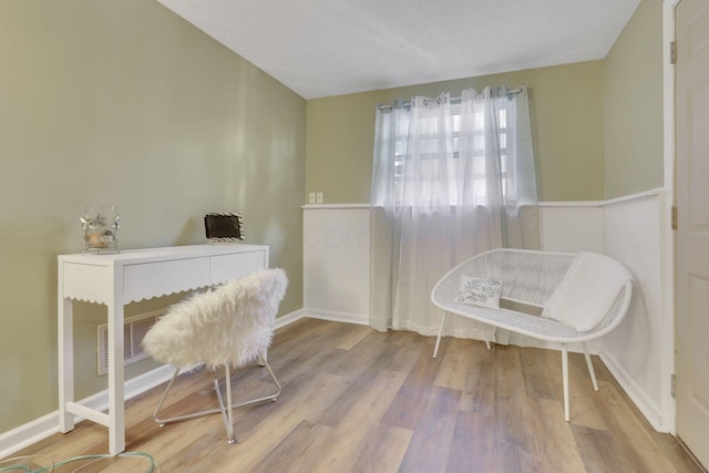 sitting room featuring a wainscoted wall, wood finished floors, and visible vents