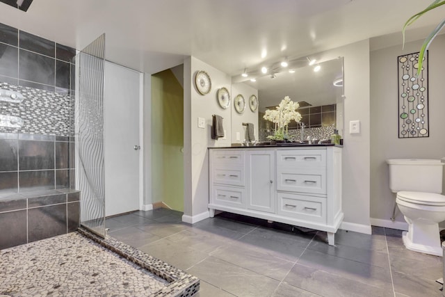 full bathroom with a walk in shower, toilet, vanity, and baseboards