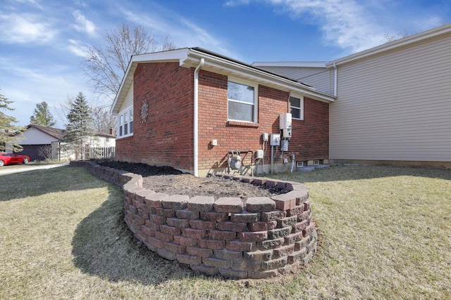 rear view of house with a lawn and brick siding