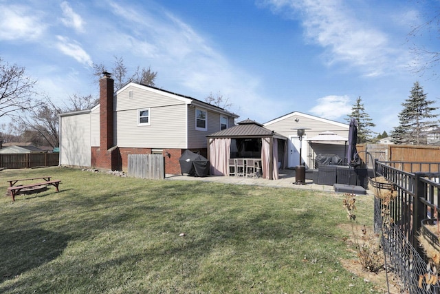 rear view of house featuring a gazebo, a yard, a patio, and a fenced backyard