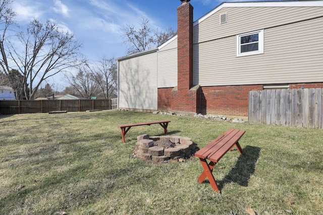 view of yard with fence and an outdoor fire pit