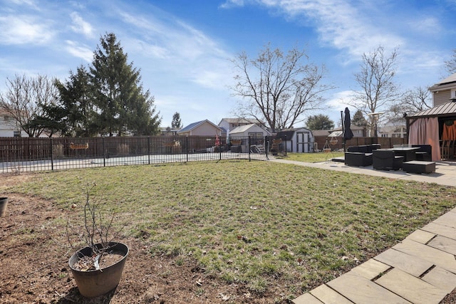 view of yard with an outdoor living space, fence, an outdoor structure, a storage unit, and a patio