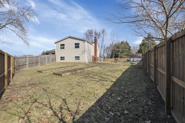 view of yard featuring a garden and a fenced backyard