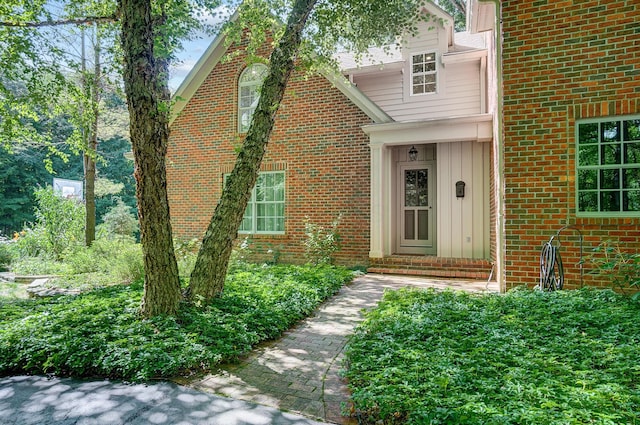 view of exterior entry featuring brick siding