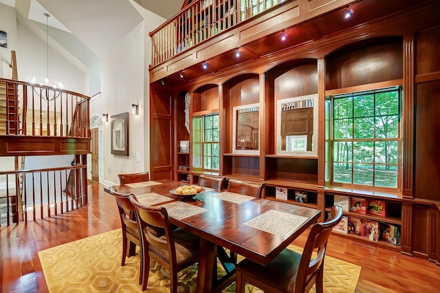 dining room with a high ceiling, plenty of natural light, and wood finished floors