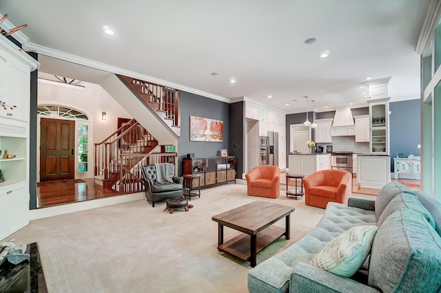 living area featuring stairway, ornamental molding, recessed lighting, and light carpet