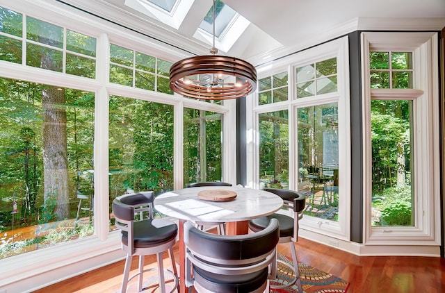 sunroom / solarium with a notable chandelier, a healthy amount of sunlight, and a skylight