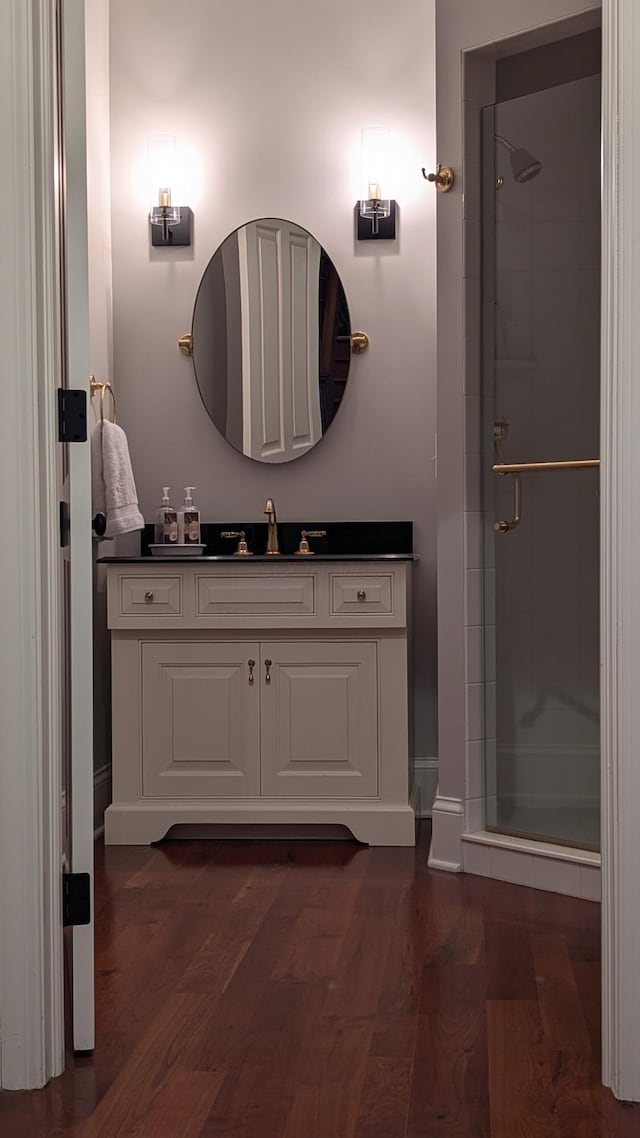 bathroom featuring a shower stall, vanity, and wood finished floors