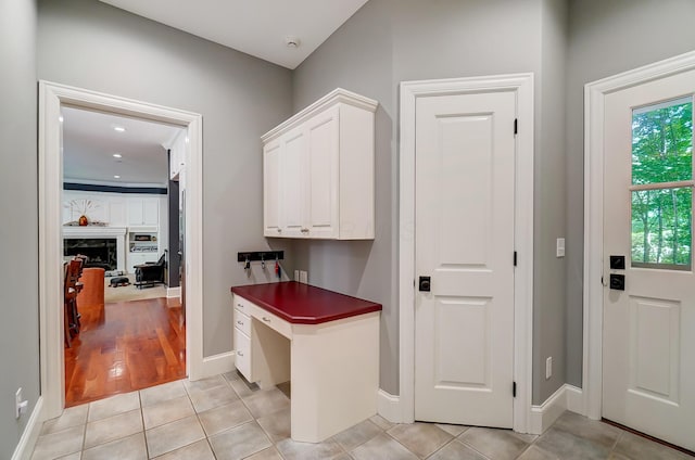 hallway with light tile patterned flooring and baseboards