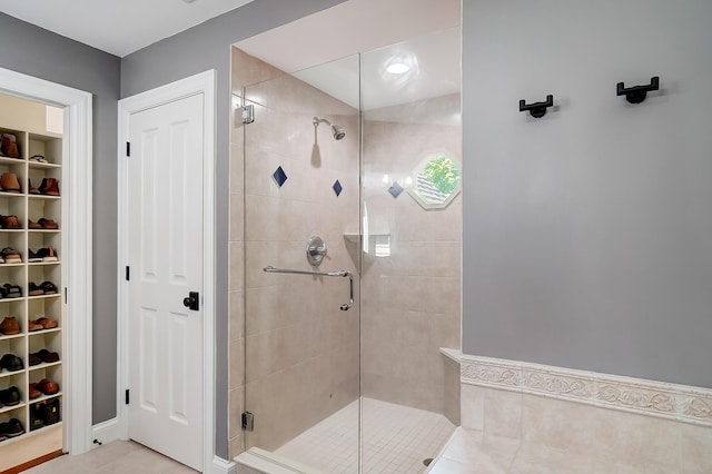 full bathroom featuring a spacious closet and a shower stall